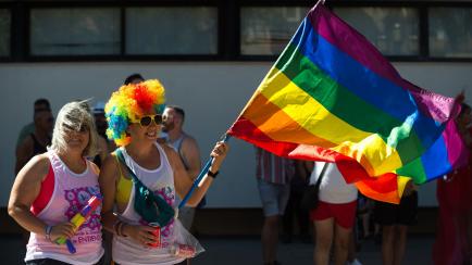 Dos mujeres ondean una bandera LGTBI en una manifestación en Málaga, el 4 de junio de 2022.  