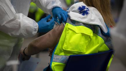 A health worker administers the Pfizer-BioNTech COVID-19 vaccine to member of Madrid Emergency Service (SUMMA) in Madrid, Spain, Tuesday, Jan. 12, 2021. Spain's rate of infection has shot up to 435 cases per 100,000 residents in the past two wee...