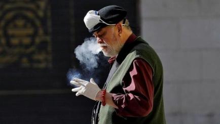 Un hombre fumando en la calle.