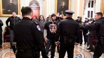 La Policía discute con un grupo de conspiranoicos de QAnon durante el asalto al Capitolio.
