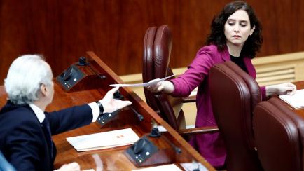 La presidenta de Madrid, Isabel Díaz Ayuso, entrega al consejero de Sanidad, Enrique Ruiz Escudero unos papeles este jueves.