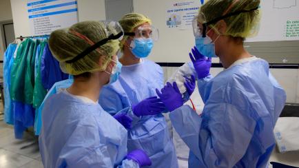 Healthcare workers chat at the Gregorio Maranon University Hospital in Madrid on May 14, 2020. - One of the world's worst-hit countries in which the virus has killed nearly 27,000 people, Spain has begun a cautious process of slowly lifting its ...