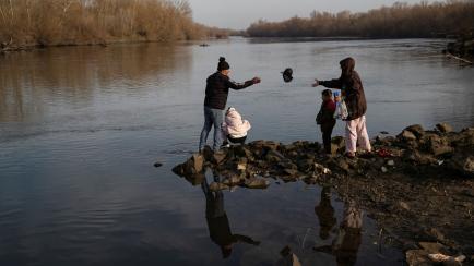 Un grupo de niños y adultos migrantes en el río Evros, entre Turquía y Grecia, el marzo de 2020.