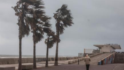 Una persona pasea cerca de la playa en Valencia con un temporal fuerte.