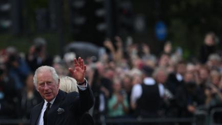 Carlos III saludando a la gente a las puertas del Palacio de Buckingham.