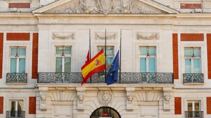 Las banderas de la Comunidad de Madrid, de España y de la UE, a media asta en la sede de la Comunidad de Madrid.