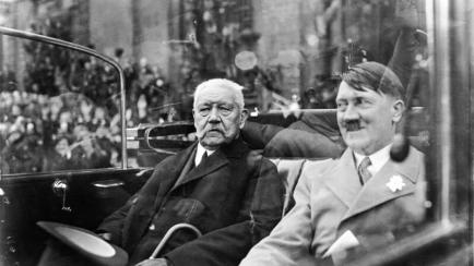 El presidente de Alemania Paul von Hindenburg y el canciller Adolf Hitler sentados en un automóvil en 1933.
