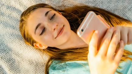 Una adolescente, con su teléfono móvil.