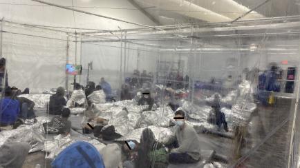 Migrantes se agolpan en una sala con plásticos en Donna, Texas.