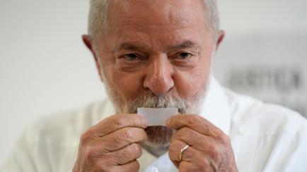 El expresidente brasileño Luiz Inácio Lula da Silva, ahora otra vez candidato, besa la papeleta electoral tras votar, el 30 de octubre de 2022, en Sao Paulo, Brasil. (Foto AP/André Penner)