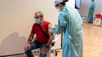Una enfermera pone una dosis de la vacuna de AstraZeneca a un hombre en Palacio de Congresos de Santander.