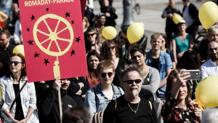 Un grupo de personas se manifiestan junto a la puerta de Brandemburgo en Berlín en el Día Internacional del Pueblo Gitano.