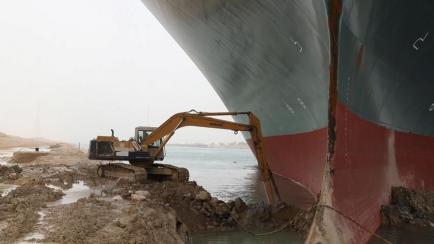 La excavadora intentando liberar el Ever Given en el Canal de Suez.
