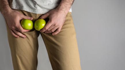 Hombre tocándose "las manzanas" sobre los pantalones.