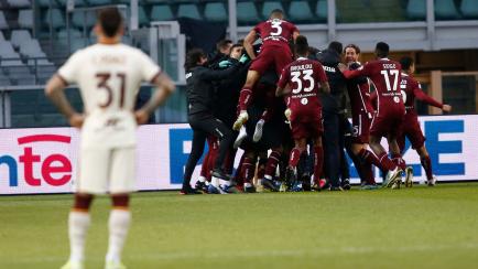 Un jugador del Torino observa cómo la plantilla de la Roma celebra la victoria en un partido de liga italiana