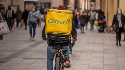 Un repartidor de Glovo circula por una calle peatonal de Barcelona. 