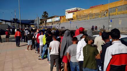 Inmigrantes marroquíes hacen cola ante la oficina de Asilo y Refugio de la frontera del Tarajal, en Ceuta.