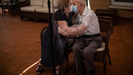 Agustina Cañamero, de 81 años, abraza y besa a su marido Pascual Pérez, de 84.