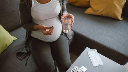 Imagen de archivo de una embarazada tomando un medicamento.