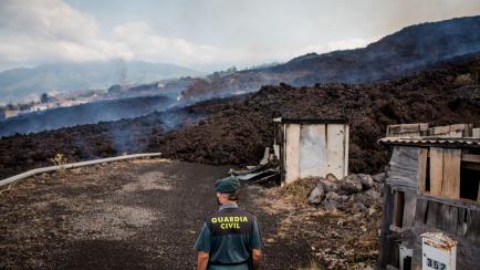 Un miembro de la Guardia Civil custodia los restos de un área devastada por la lava