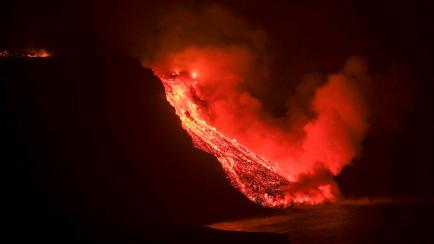 La colada de lava que emerge de la erupción volcánica de La Palma ha llegado esta noche al mar en una zona de acantilados situados en las cercanías de la playa El Guirre, en Tazacorte