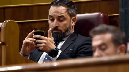 Santiago Abascal consulta su móvil en el escaño.