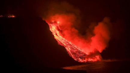 La colada de lava llega este martes al mar en una zona de acantilados, en La Palma.