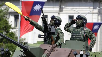 Taiwanese soldiers salute during National Day celebrations in front of the Presidential Building in Taipei, Taiwan, Sunday, Oct. 10, 2021. (AP Photo/Chiang Ying-ying)