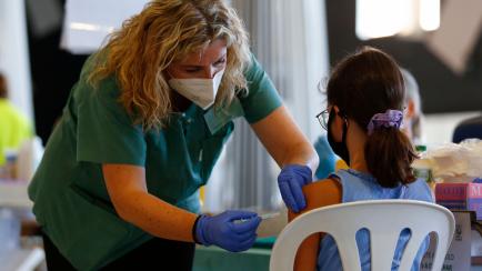 Una enfermera pone la vacuna contra el coronavirus a una niña en Granada.