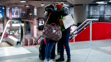 Dos personas se abrazan en la estación de Atocha (Madrid), el 23 de diciembre. 