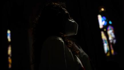 Una mujer con mascarilla la misa del Corpus en la Catedral de la Almudena de Madrid, el 14 de junio de 2020.