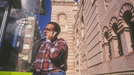 Un hombre habla desde una cabina telefónica en Cádiz.