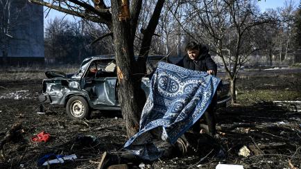 Un hombre cubre con una manta un cadáver en la ciudad ucraniana de Chuguiv, en el este.