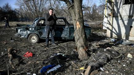 Un hombre llora ante un muerto tras el ataque ruso contra la ciudad de Chuguiv, en el este de Ucrania.