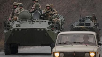 Militares ucranianos se trasladan en vehículos blindados por una carretera.
