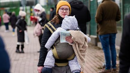 Una mujer ucraniana, con su bebé, busca cruzar la frontera tras la invasión rusa.