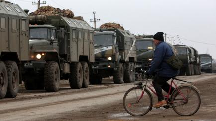 Un hombre pasa con su bicicleta ante tanques rusos en la ciudad de Armyansk, Crimea, el 25 de febrero. 