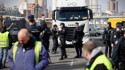Agentes del Cuerpo Nacional de Policía escoltan este lunes a uno de los camiones que ha salido del puerto de A Coruña.