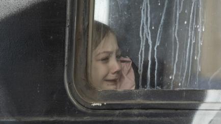 Una niña refugiada de Ucrania llora en un autobús. 
