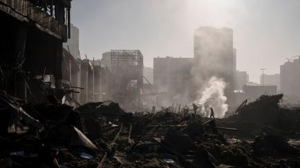Unos bomberos extinguen un fuego cerca del centro comercial atacado en Kiev, el 21 de marzo. 
