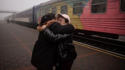 Dos personas se abrazan en una estación de tren de Jersón. 