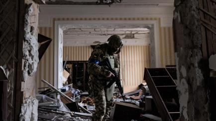Un soldado ucraniano revisando los destrozos de un bombardeo en un edificio residencial en Járkov.