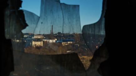 La ciudad de Járkov fotografiada a través de una ventana rota.
