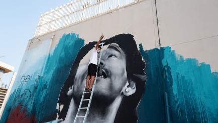 Un artista callejero pinta un grafiti en honor a Maradona en Qatar