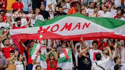 Aficionados iraníes sostienen carteles de "Woman Life Freedom" durante el partido del Mundial de Qatar 2022 contra Inglaterra. 