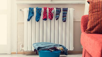 Tub with freshly washed laundry and socks hanging on the radiator