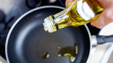 Imagen de archivo de una persona cocinando con aceite de oliva.