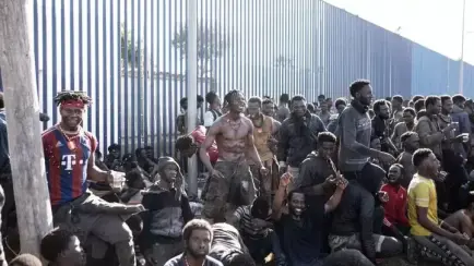 Un grupo de migrantes, alrededor de la valla que separa España y Marruecos.