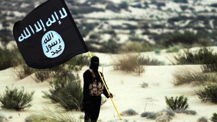 Un miembro del ISIS posa con una bandera de su grupo terrorista