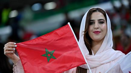 Una mujer exhibe una bandera de Marruecos.